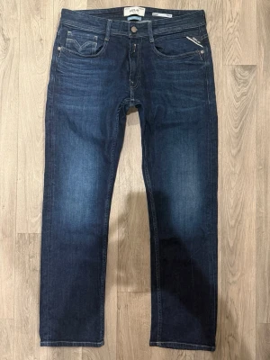 Replay Rocco Jeans Mörkblå W31/L30 - Regular Fit - Replay Rocco mörkblå jeans med regular fit passform som sitter bekvämt med rak benform och avslappnad känsla, storlek W31/L30, midja 41,5 cm, ytterbenslängd 98 cm, benöppning 18,5 cm, modellen är 185cm & väger 65kg, i fint skick.