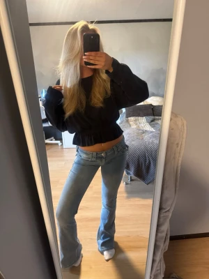 True Religion Joey ljusblå flare jeans - Säljer ett par ljusblå Joey jeans från True Religion med låg midja och utsvängda ben. Klassisk femficksmodell med snygga sömmar och knappdetaljer💕 De har lite slitningar längst ner vid bena och en lite fläck som inte går bort annars är dom hela och rena🥰