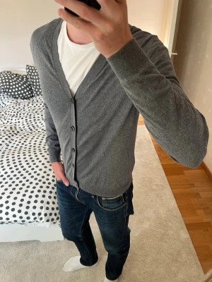 Grå tunn kofta med knappar från Massimo Dutti - Väldigt snygg grå stickad kofta från Massimo Dutti i storleken M. Tröjan är riktigt skön då den är tillverkad av cashmere, silke och bomull! ✌🏼——————————————————————————                                                                      📐| Storlek: M                                                           👖| Märke: Massimo Dutti                                      🔎| Skick: Mycket Fint                                                      ✍🏻| Skriv om du har några frågor