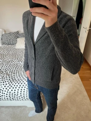 Mörkgrå stickad cardigan - Säljer en sjukt fet stickad cardigan från Hollister gjord i ett väldigt skönt material. Cardiganen är i ett väldigt fint skick utan defekter! ✌🏼——————————————————————————                                                                      📐| Storlek: M                                                           👖| Märke: Hollister                                                🔎| Skick: Mycket Fint!                                                     ✍🏻| Skriv om du har några frågor