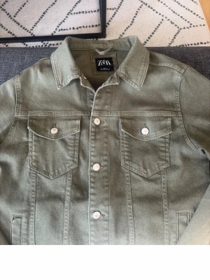 Olivgrön jeansjacka från ZARA - Snygg olivgrön jeansjacka från ZARA , silver knappar och två bröstfickor med knapp. Jacka passar många feta outfits. Men tyvärr har den blivit för liten 
