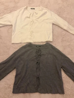 Två koftor med knytning framtill - Säljer två koftor ifrån gina tricot, en i vitt och en i grått. Båda är i storlek small. 