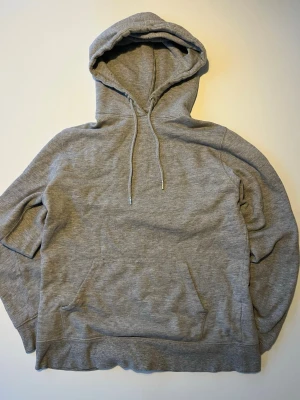 Lager 157 Hoodie Grå Basic - Grå melerad basic-hoodie från Lager 157. Luva med dragsnören, kängurficka fram, ribbstickade linningar vid ärm och midja. Klassisk mjuk sweatshirt-kvalitet.  Skick: Mycket bra  Storlek: S  Skickas snabbt! 📦