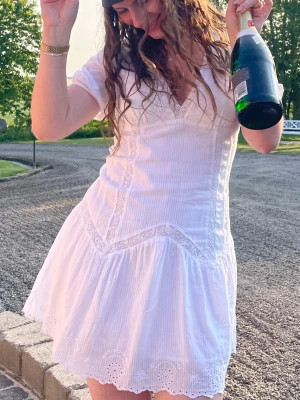 Zara Vit kort klänning med spetsdetaljer - Söt vit kortklänning med spetsdetaljer och v-ringning. Från Zara. Storlek M men liten i storlek så mer som en S💞