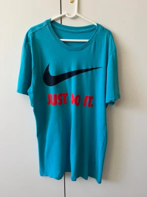 Blå t-shirt med tryck strl S - Blå t-shirt med tryck. Storlek S. Etikett om material och storlek har klippts.
