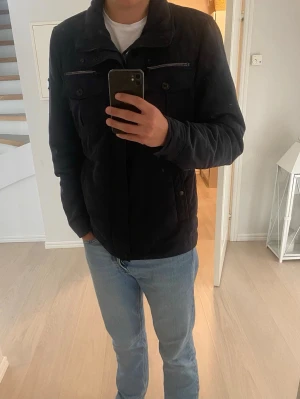 Jacka J.Lindeberg  - Snygg mörkblå fieldjacket från J.Lindeberg. Storlek: XL men sitter som L. Personen på bilden är 189cm. Välskött och är i bra skick