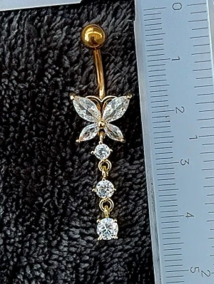 NY oanvänd Navelpiercing med hänge | Kirurgiskt stål | Fjäril och vita stenar  - 💕30% Bundle-rabatt vid köp av minst 2 artiklar. ⭐️NY oanvänd piercing i kirurgiskt stål; rostfritt och säkert för läkta piercingar.                               📏MÅTT ⭕️Stavens längd: 10mm ⭕️Stavens tjocklek: 1,6mm ⭕️Smyckets totala längd: 40mm                                                                         🤍Färger: Guld och vit                                                           💌Skickas spårbart via Plick SafePay.