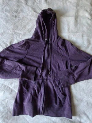 Lila zip hoodie från H&M - Säljer en lila hoodie från H&M Sport i storlek M. Hoodien har dragkedja framtill, två fickor och justerbar huva med snören. Knappt använd.