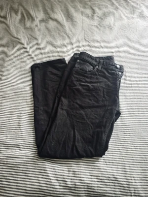 Svarta tapered jeans Tapered/Mike - Säljer ett par svarta tapered jeans i modellen Tapered/Mike. Klassisk femficksdesign med knappgylf och raka ben. Jeansen har en stilren look och passar perfekt till en avslappnad streetwear-stil. Materialet är mjukt och bekvämt denim.