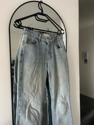 Ljusblå lågmidjade jeans - Lågmidjade ljusblå jeans med utsvängda ben, i väldigt bra skick men har en mindre fläck på benet som förmodligen går bort i tvätt. 💕