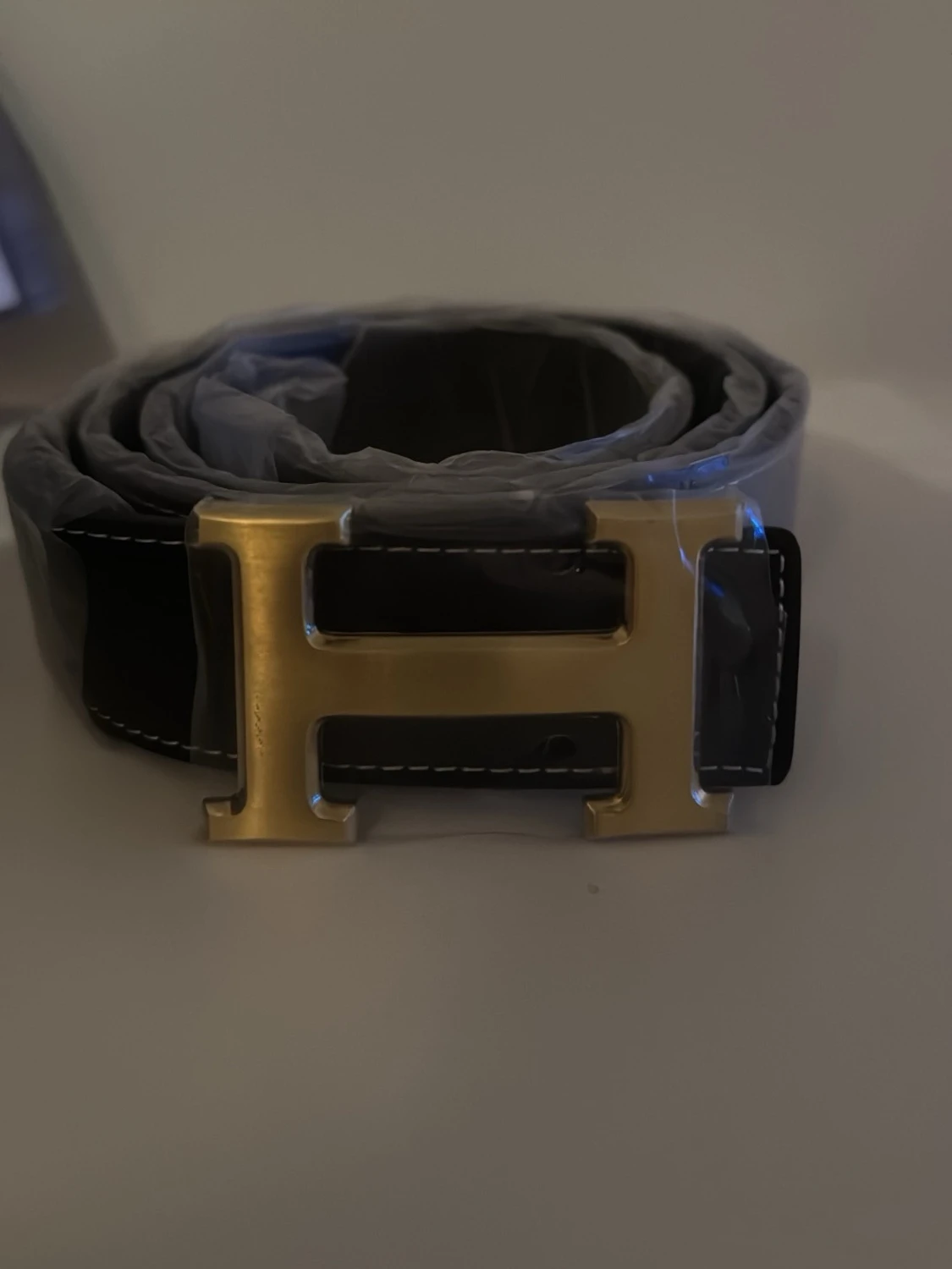 Svart bälte med H märke.