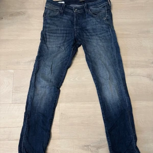 Mörkblå jeans - Säljer ett par mörkblå jeans från jack&jones med raka ben och klassisk femficksdesign. Jeansen har snygga kontrastsömmar för en cool look. Passar perfekt till en avslappnad stil och är tillverkade i denim med lite stretch.