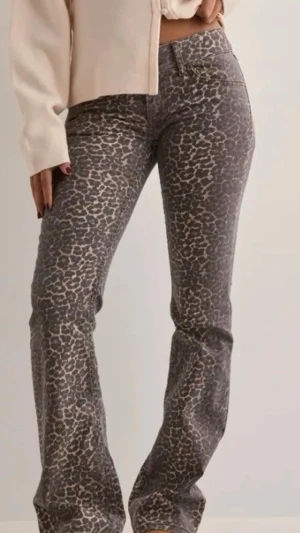 Leopardmönstrade bootcut jeans - Säljer ett par trendiga leopardmönstrade jeans med bootcut passform. Jeansen har låg midja Färgen går i gråbruna toner med svart och beige toner. Dem är använda fåtal gånger och har pyttelite slitning vid sömnen längst ner.