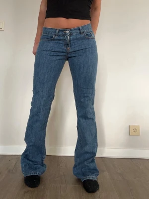 Blå bootcut jeans - Klassiska blå bootcut jeans med mid rise midja och femficksmodell. Jeansen har en snygg tvätt och raka ben som går ut lite nedtill. Vi kan även göra special anpassningar om du önskar extra hål i jeansen!! Startar från 50kr extra. I jeansen stor det storlek 40 men sitter snarare som storlek 34!