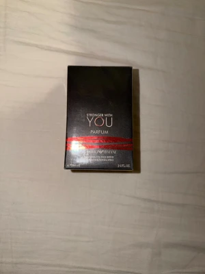 Stronger With You Parfum 100ml - Stronger With You Parfum från Giorgio Armani i en elegant svart kartong med röda detaljer. Flaskan rymmer 100 ml och doften är intensiv och modern, perfekt för dig som gillar exklusiva parfymer. Snygg design som känns lyxig och tidlös.