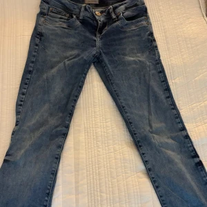 Blå jeans från LTB Blue Addicted - Snygga blå jeans från LTB Blue Addicted med klassisk femficksdesign och slitna detaljer. Jeansen har normal passform, låg midja och raka ben. De har två defekter och det är på bilderna❣️är öppen för prisförslag . Hålet som finns är ordentligt sytt och går ej upp , det är sytt på maskin ordentligt med ett annat jeans tyg. Man märker ingenting av det