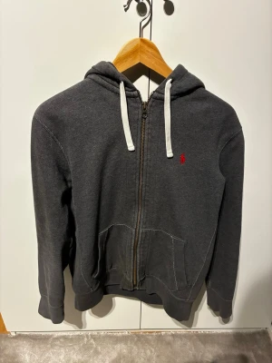 Mörkgrå zip hoodie från Polo Ralph Lauren - Mörkgrå hoodie med dragkedja från Polo Ralph Lauren. Storlek M men kan även passa S.