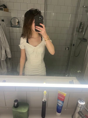 Vit kort omlottklänning med volang - Söt vit kortklänning med omlottdesign och volangdetaljer. Klänningen har korta puffärmar och en smickrande v-ringning med knyt framtill. Perfekt för sommarens alla tillfällen. Säljer den då den inte kommer till användning längre, kontakta mig om ni har frågor💕