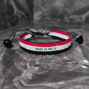 Handgjort armband Irakiska flaggan - ✨️Justerbart, enkelt att öppna och stänga ✨️Kan stängas till en 15cm omkrets och öppnas bredast till ca 27cm omkrets ✨️Höjden av flagg-delen är 1,3cm ✨️Flagg-delen minus "glidknuten" är 14cm lång ✨️Skickas inom en vecka så fort tillverkningen är klar