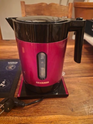 Röd vattenkokare Severin 1,2L - Elektrisk vattenkokare från Severin i metallicröd och svart plast. Rymmer upp till 1,2 liter och har tydlig nivåindikator på sidan. Modern design med sladd och avtagbar basplatta. Perfekt för att snabbt koka vatten till te eller kaffe.