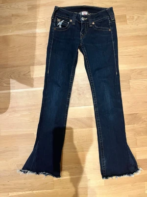 True Religion Bootcut Jeans - Lågmidjade True Religion Bootcut Jeans Storlek 27 Mått rakt över midjan 36/37cm Innerbenslängd 78/79cm  Priset kan diskuteras och sänkas en del!