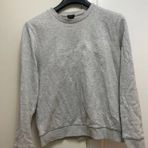 Grå sweatshirt från Hugo Boss - Snygg grå sweatshirt från Hugo Boss med broderad logga på bröstet. Tröjan har rund halsringning, långa ärmar och ribbade muddar vid ärmslut och nederkant. Perfekt för en avslappnad och stilren look.