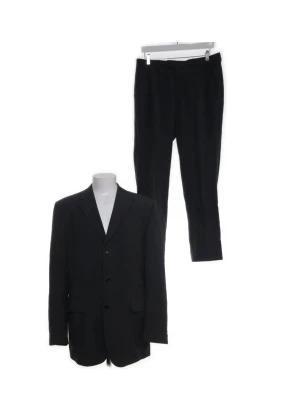 Kostymset från Tiger of Sweden, nypris runt 5 000 kr - Säljer en riktigt snygg kostym från Tiger of Sweden, storlek 52. Klassisk modell i mörk grå/svart ton.  Tillverkad i 100% ull så den faller fint och känns kvalitativ. Helfodrad med viskos på insidan vilket gör den skön att bära. Kavajen är enkelknäppt med tre knappar vid ärmsluten elegant design som funkar lika bra på jobbet som på bröllop eller fest. Om du vill ha fler bilder kontakta mig Ärmlängd (cm) 67  Midjemått (cm) 92  Axelbredd (cm) 50  Innerbenslängd (cm) 83