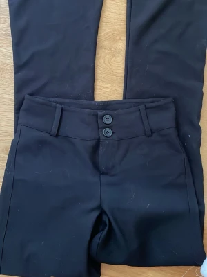 Svarta lowrise bootcut kostym byxor - Jag är så ledsen att jag behöver sälja denna kostymbyxan men jag går verkligen inte i den längre! 🥲 Säljer ett par svarta bootcut kostymbyxor med klassisk passform. De är lite noppriga som man ser på bilden.