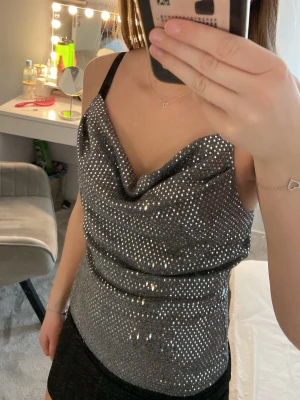 Fest topp - Säljer en snygg silvrig glittrig fest topp i storlek XS från Sisters Point. Inga defekter, fint skick, endast använd en gång 