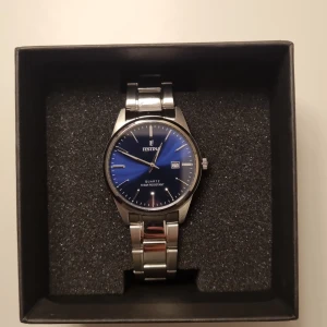 Festina klocka med blå urtavla - Stilren klocka från Festina med metallarmband i silver och en snygg blå urtavla. Klockan har datumvisning och klassisk rund form. Perfekt accessoar för dig som gillar en tidlös look.
