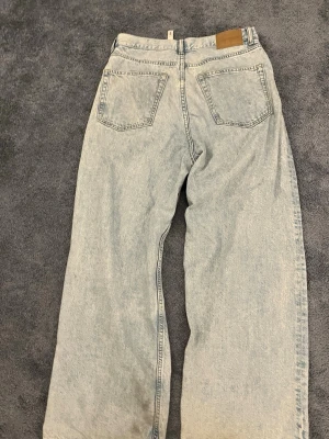 Ljusblå astro baggy jeans från weekday - Säljer ett par ljusblå weekday jeans med breda ben och klassisk femficksdesign. Jeansen har en avslappnad passform och är tillverkade i slitstarkt denim. Perfekta för dig som gillar en loose och trendig stil.