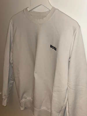 Vit sweatshirt från BOSS - Säljer en vit sweatshirt från BOSS. Jätte fin tröja passar till allting.