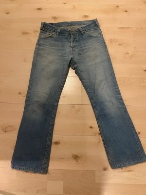 Lee jeans - Vintage par Lee jeans.  Kan inte säga storleken som visas på byxorna då det blir vilseledande (pga vintage).  Utgå från denna information:  längd: 182,5  vikt: 77kg  Jag brukar använda levi 32/32. OBS: slitage på ena sidan av byxorna runt höftnivå, syns på bild. Sytt ihop.