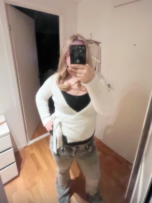 Grå bootcut jeans med slitningar - Säljer ett par grå bootcut jeans med snygga slitningar och tvättade detaljer. Jeansen har låg midja, klassiska fem fickor och stängs med knapp och dragkedja. Perfekta för en avslappnad och trendig look.