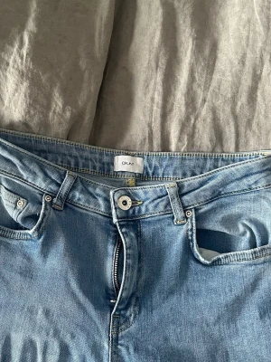 Ljusblå raka jeans från grunt - Säljer ett par ljusblå jeans från grunt med klassisk femficksdesign och raka ben. Jeansen har dragkedjegylf och bälteshällor, perfekta till en avslappnad stil. Materialet är mjukt denim i bomull för skön känsla hela dagen.