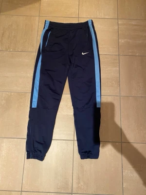 Nike vintage byxor  - Nike vintage byxor i marinblå med ljusblå detaljer. Storlek xs-s. Jättesnygga och i väldigt bra skick. 