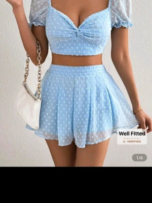 Ljusblå prickig croppad topp och shorts - Supersöt ljusblå croppad topp och shorts med puffärmar och små prickar. Perfekt för dig som vill ha en feminin och trendig look.