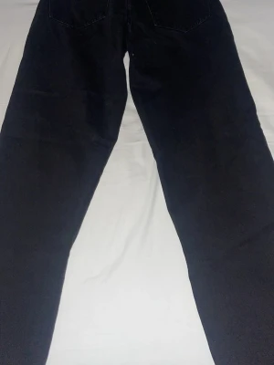 Svarta raka manchesterbyxor - Säljer ett par svarta manchesterbyxor med raka ben och klassisk femficksdesign. Byxorna har breda revärer och är tillverkade i mjuk manchester som ger en retrovibe. Perfekta för dig som vill ha en stilren och avslappnad look.