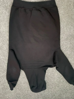 Svart Burberry hoodie med logga - Snygg svart hoodie från Burberry med klassisk beige patch och logga på magen. Hoodien har huva och en stor magficka. Tillverkad i mjukt bomullsmaterial som känns skönt mot huden. Perfekt för dig som vill ha en stilren och trendig look.