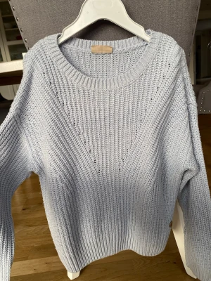 Ljusblå stickad tröja  - Mysig ljusblå stickad tröja. Perfekt för dig som gillar en enkel men söt stil. Köparen står för frakt.