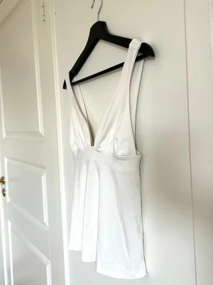 Vit ärmlös linnetopp från Nelly - Superfin topp från Nelly med knytning i ryggen. Använd några få gånger men helt ny i skick! STORLEK - S