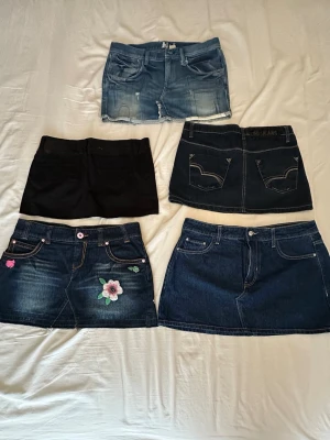 Blå jeanskjol med broderad blomma - Skicka ett privat meddelande om du gillar någon av dem för att fråga om pris och storlek på varje plagg.