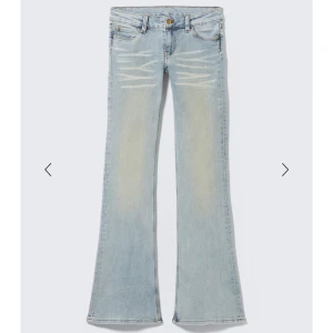 Ljusblå bootcut jeans med slitningar - Snygga ljusblå jeans med bootcut passform och slitna detaljer framtill. Jeansen har en klassisk femficksdesign och är tillverkade i mjukt denimtyg. Perfekta för dig som gillar retrovibbar och vill sticka ut med en cool siluett. Strl 26/30