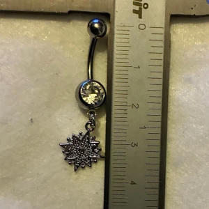 ✨ NY oanvänd navelpiercing med hänge - Kirurgiskt stål 316L  - ✨ NYTT oanvänt smycke i kirurgiskt stål! 🌸 Hållbart & Rostfritt: Slitstarkt 316L-stål som inte oxiderar eller rostar av fukt. 🌸 Säkert: Industristandard, skonsamt för läkta piercingar.  🛍️ 30 % BUNDLE-RABATT! Köp fler artiklar från min shop och få 30 % på allt! ✨ 📦 Frakt: Endast spårbart via Plick SafePay för vår trygghet.