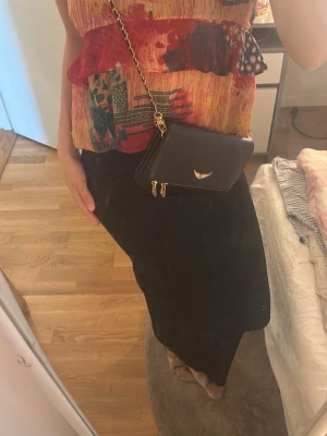 Färgglad linnetopp med volang - Säljer en unik och färgglad linnetopp med volangdetaljer och tunna axelband. Toppen har ett abstrakt mönster i rött, gult, grönt och blått samt inslag av prickar. Materialet känns lätt och luftigt, perfekt för varma dagar. Passar dig som vill sticka ut med din stil.