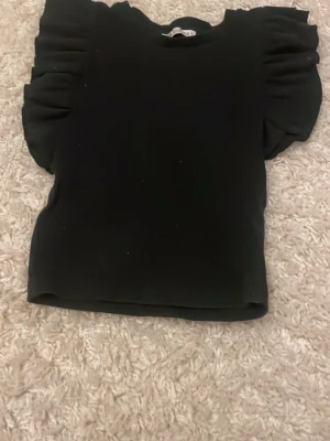 Svart topp med puffärmar - Svart topp med fina detaljer vid ärmarna. Den är i storlek S men skulle nog säga att den passar för den som har XS också, den är ganska kort i modellen tycker jag. Skriv gärna för fler frågor💕
