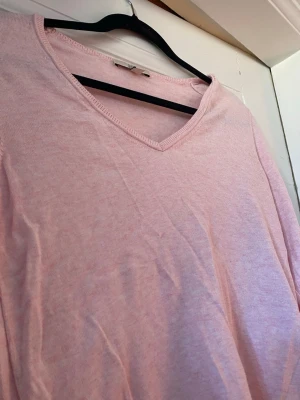 Ljusrosa V-ringad tröja från Esprit - Säljer en ljusrosa långärmad tröja från Esprit med V-ringning. Tröjan är tunn och mjuk, perfekt för lager på lager eller som den är. Enkel och stilren design som passar till det mesta. Materialet känns som bomull eller bomullsblandning.