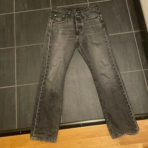 Levi's 501 - Säljer ett par Levi's 501 jeans i svart tvättad denim.  Jeansen är använda men är i bra skick (inga hål eller sådant) w28 l30