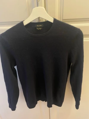 Mörkblå kashmirtröja Massimo Dutti - Snygg mörkblå stickad tröja från Massimo Dutti i mjuk kashmir. Klassisk rund halsringning och långa ärmar. Perfekt basplagg för dig som gillar stilrena och bekväma outfits.