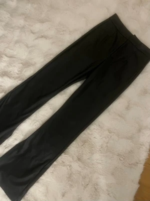 Bershka läderbyxor - Trendiga svarta bootcut läderbyxor med slits från Bershka, köpta nya på vinted och sedan dess aldrig använda
